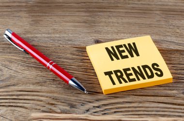 YENİ TRENDS yapışkan bir metin ve ahşap arka planda kalem
