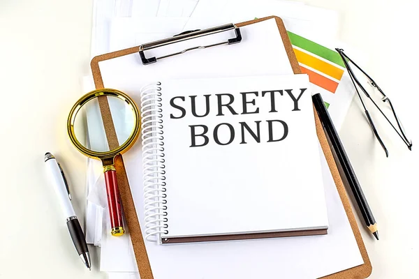 Surety Bond Texto Cuaderno Con Portapapeles Sobre Fondo Blanco — Foto de Stock