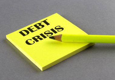 Gri arkaplanda yapışkan üzerine yazılmış DEBT CRISIS metni
