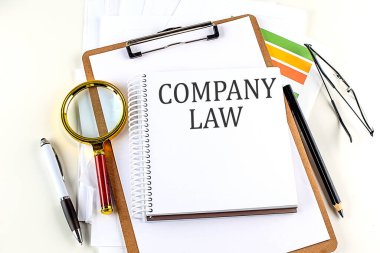 Beyaz arkaplan üzerinde pano olan bir dizüstü bilgisayarda COMPANY LAW metni