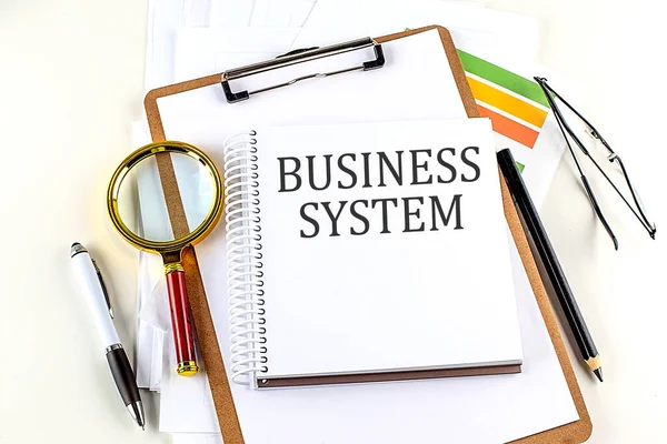 白を背景にクリップボード付きノートブックのビジネスシステムテキスト — ストック写真