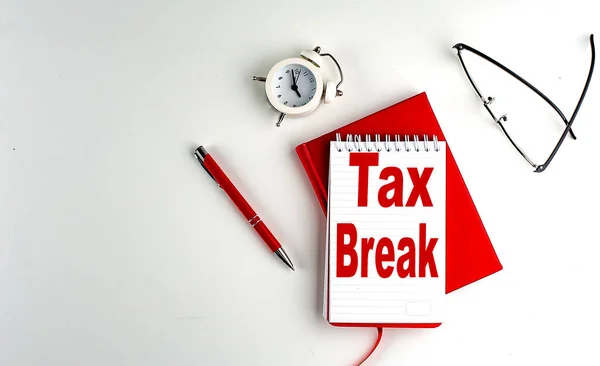 stock image TAX BREAK text on a notebook , red pen and notebook, business concept, white background