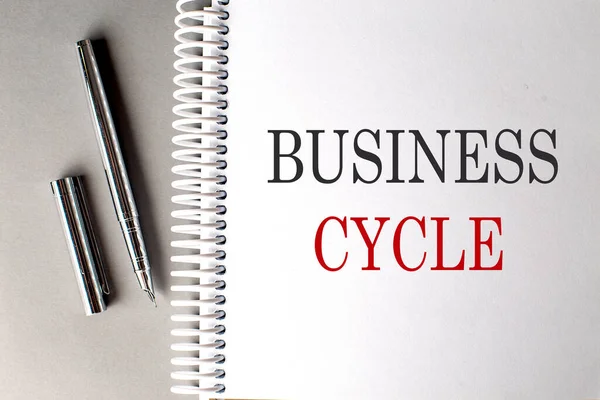 Bedrijfsleven Cycle Tekst Een Notitieboekje Met Pen Een Grijze Achtergrond — Stockfoto