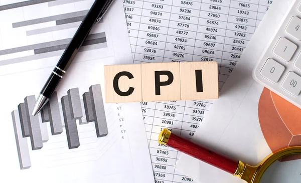 stock image CPI text on a wooden block on graph background with pen and magnifier