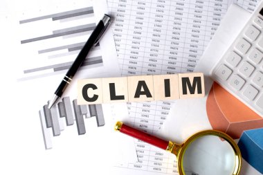 Grafik arkaplanındaki tahta blokta kalem ve büyüteçle CLAIM metni