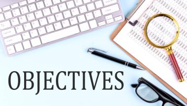 Klavye ve pano ile mavi arkaplan üzerinde OBJECTIVES metin, iş konsepti
