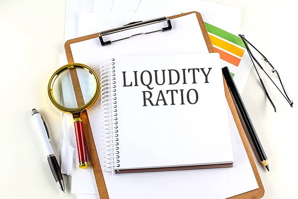 stock image LIQUIDITY RATIO text on a notebook with clipboard on white background