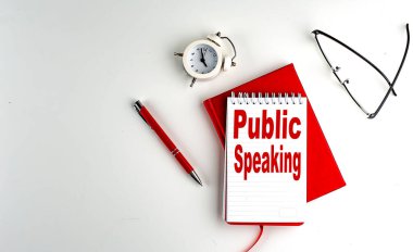 Bir defter, kırmızı kalem ve defter, iş konsepti, beyaz arkaplan üzerindeki PUBLIC konuşma metni