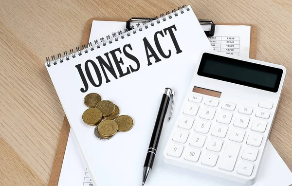 stock image JONES ACT text with chart and calculator and coins , business