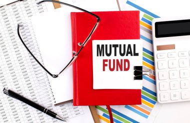 Çizelgesi, hesap makinesi ve kalemi olan bir defter üzerindeki MUTUAL FUND metni