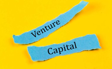 VENTURE CAPITAL metin üzerinde mavi kağıt parçaları sarı arkaplan, iş konsepti