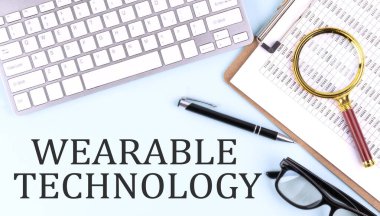 Klavye ve klavye ile mavi arkaplan üzerinde giyilebilir TEKNOLOJİ metin, iş konsepti