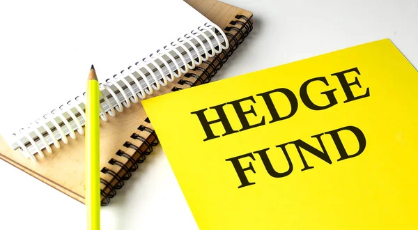 stock image HEDGE FUND text written on yellow paper with notebook