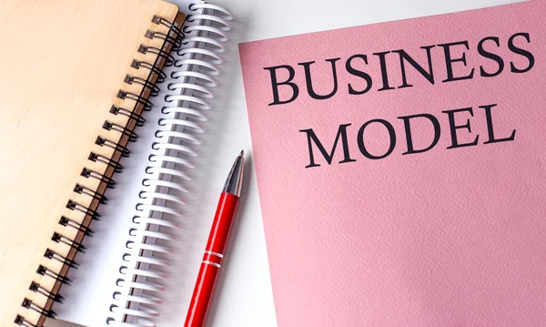 ビジネスモデル白地にオフィスツールとピンクの紙の単語 — ストック写真