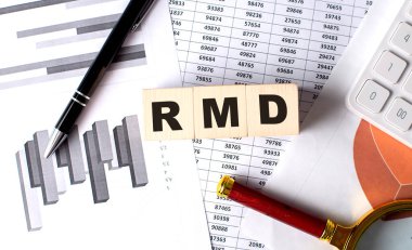 Grafik arkaplanındaki tahta blokta kalem ve büyüteçle RMD metni