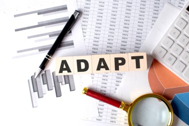 Grafik arkaplanındaki tahta bloktaki ADAPT metni kalem ve büyüteçle