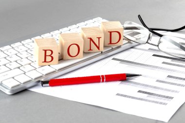 Klavyedeki tahta küpte Gri arkaplanda çizelge ile BOND yazıldı