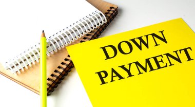 DOWN ÖDÜNCÜ Not defteriyle sarı kağıda yazılmış metin