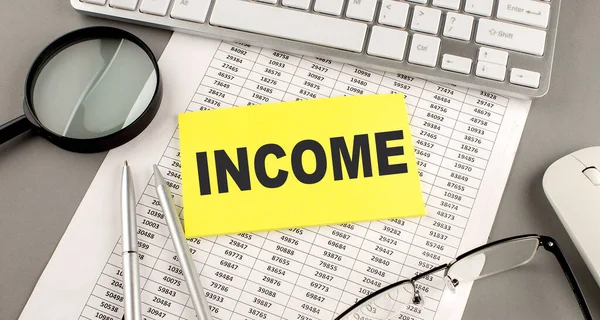 Çizelgeye klavye ve büyüteçle yazılmış INCome metni