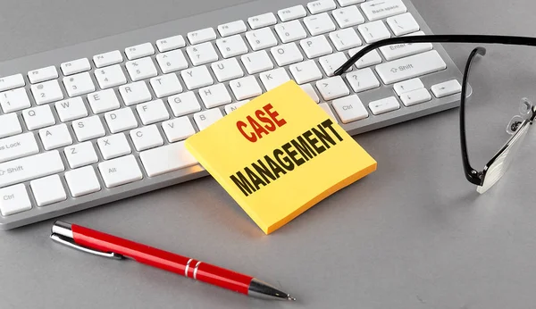 Case Management Text Sticky Keyboard Pen Glasses Grey Background — Stock Photo, Image
