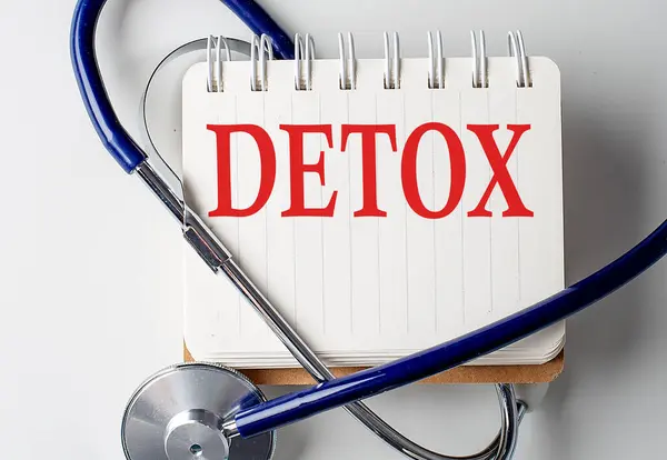 stock image DETOX word on a notebook with medical equipment on background