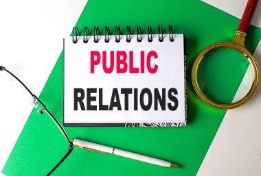 Yeşil kağıt üzerinde bir defter üzerinde POBLIC İlişkiler metni