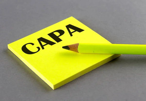 CAPA text written on sticky on grey background