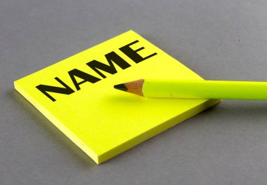 Gri arkaplanda yapışkan üzerine yazılmış isim metni