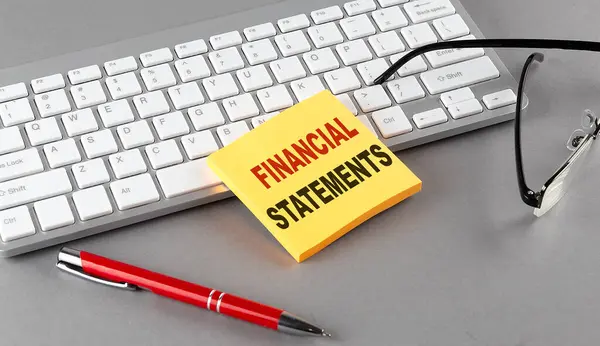 Financial Statement Text Sticky Keyboard Pen Glasses Grey Background — Stock Photo, Image
