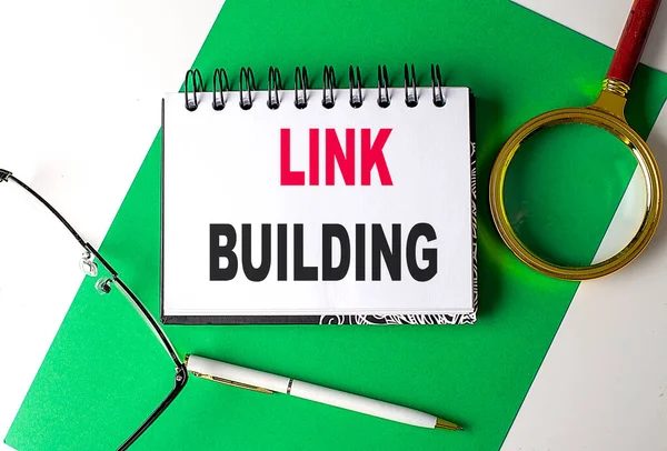 LINK BUILDING text on a notebook on green paper