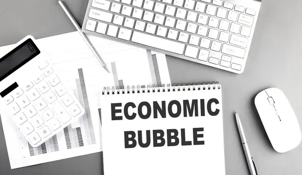 ECONOMIC BUBBLE text on a notebook with keyboard and chart