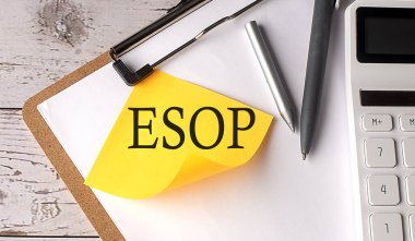 Hesap makinesi, kalem ve pano ile sarı yapışkan üzerinde ESOP kelimesi