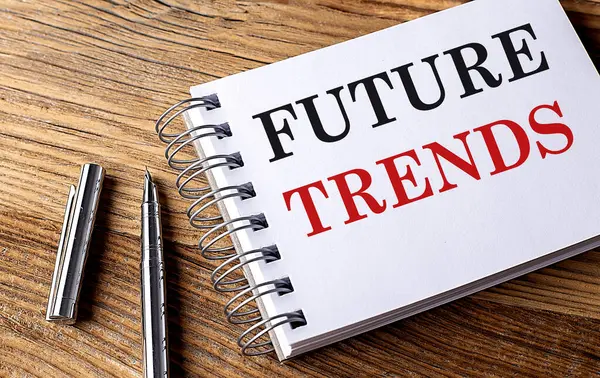 FUTURE TRENDS text on a notebook with pen on wooden background