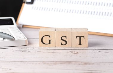 Tahta blokta pano ve hesap makinesiyle GST sözcüğü
