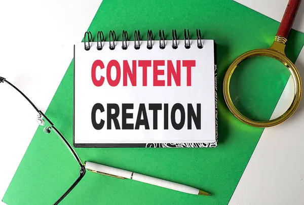 CONTENT CREATION text on a notebook on green paper