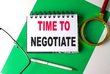 Time TONEGOTIATE Yeşil kağıt üzerinde bir defter üzerinde metin