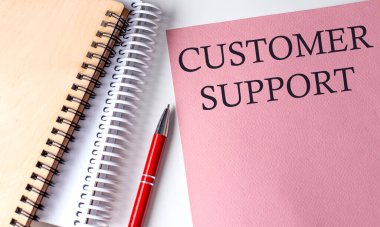 Beyaz arka planda ofis araçları ile pembe kağıt üzerine CUSTOMER ilave kelime