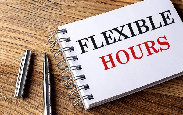 FLEXIBLE HOURS text on a notebook with pen on wooden background