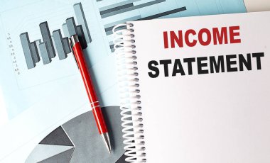 Çizelge arkaplanında kalem olan bir defter üzerindeki Gelir Durumu metni