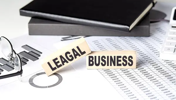 LEGAL BUSINESS - text on wooden block with chart and notebook