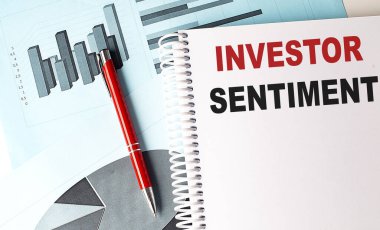 INVESTOR SENTIMENT text on notebook with pen on a chart background clipart