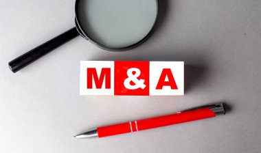 M and A word on a wooden cubes with pen and magnifier clipart
