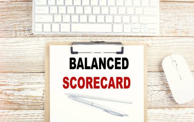 Tahta zemin üzerinde bir pano üzerinde balanslı SCORECARD metin