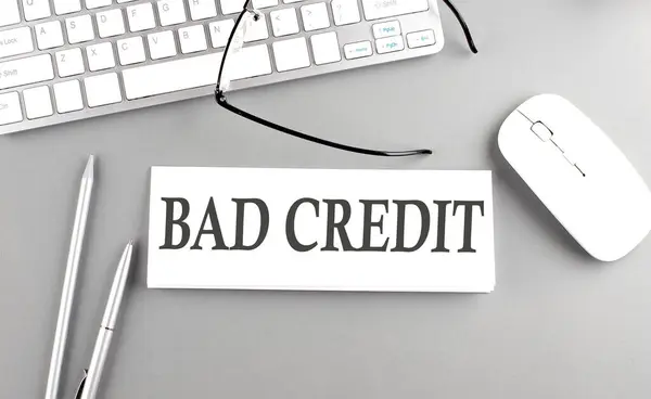 BAD CREDIT text on a paper with keyboard on a grey background