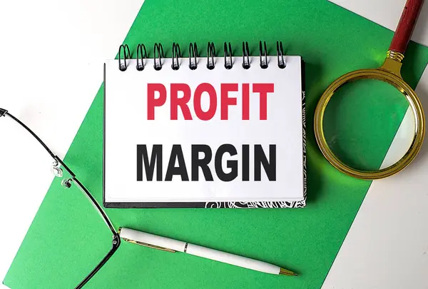 PROFIT MARGIN text on a notebook on green paper