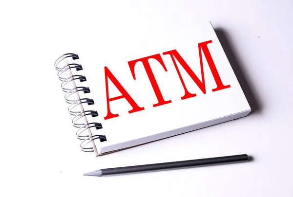 Text ATM on notebook on the white background, business