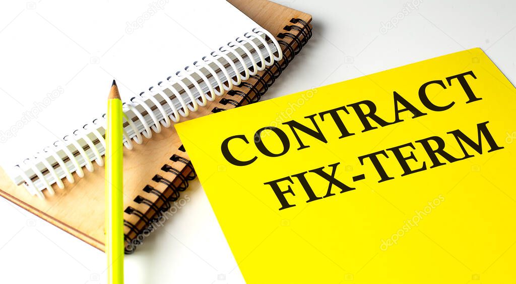 CONTRACT FIX-TERM text written on a yellow paper with a notebook