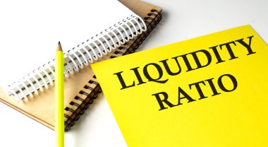 Not defteriyle sarı kağıda yazılmış LiquIDITY RATIO metni