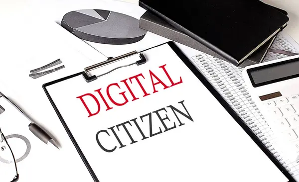 DIGITAL CITIZEN text on a paper clipboard with chart and notebook on withe background