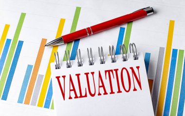 Not defterine çizelge ve kalem iş konsepti içeren VALUATION metni